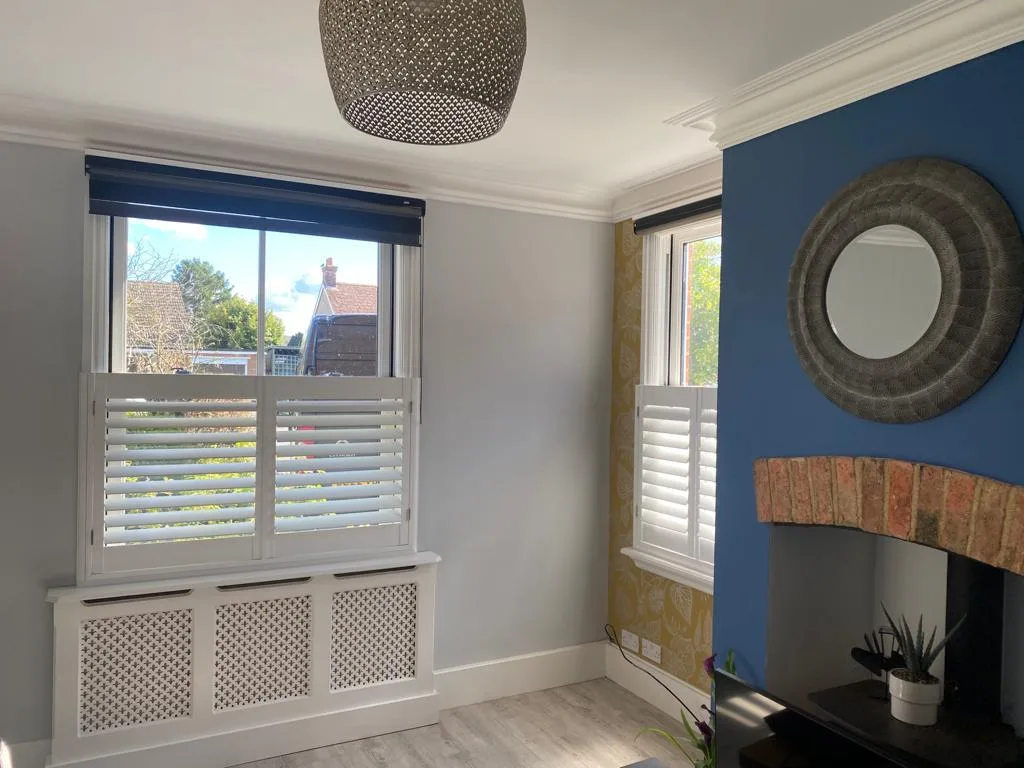 Café style plantation shutters in a modern living room with a blue feature wall.