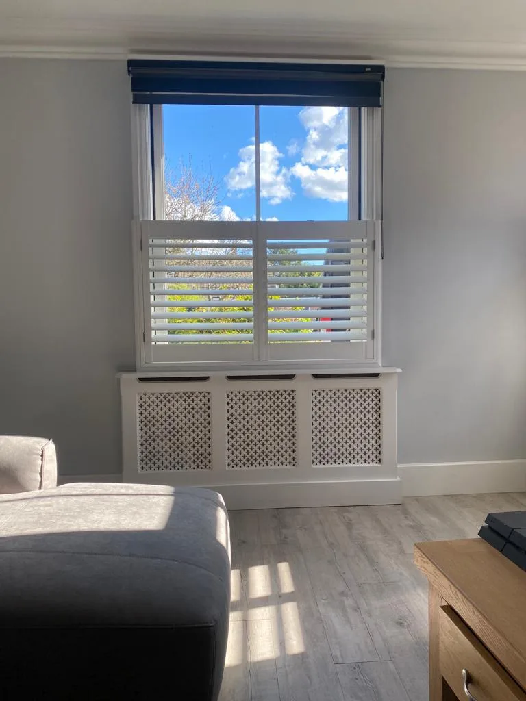 Café style shutters in a living room with a radiator cover.